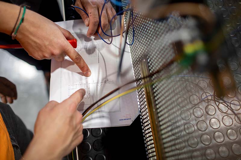 Alumnes analitzant un plànol d'un circuit elèctric dins del mòdul de Mecatrònica Industrial Alumnes analitzant un plànol d'un circuit elèctric dins del mòdul de Mecatrònica Industrial